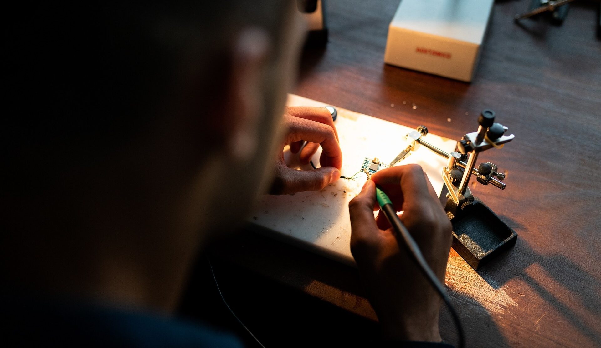 Person soldering electronic components on a circuit board.